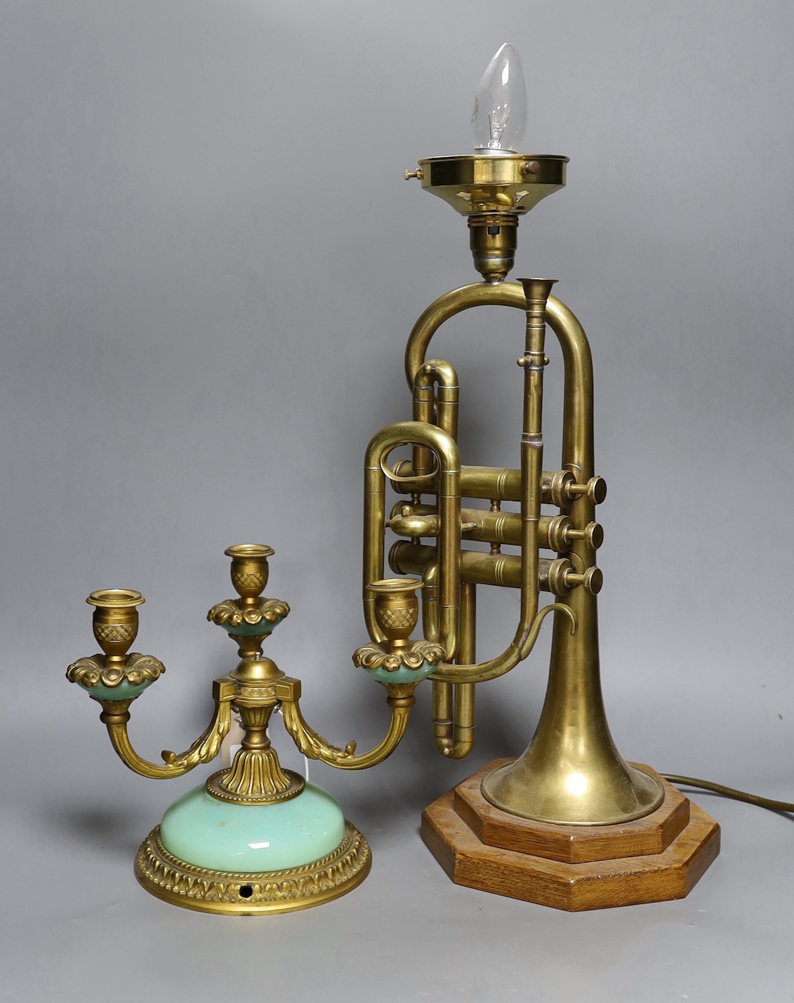 A novelty brass trumpet table lamp and three sconce brass candelabra, trumpet lamp 44cms high including fitting